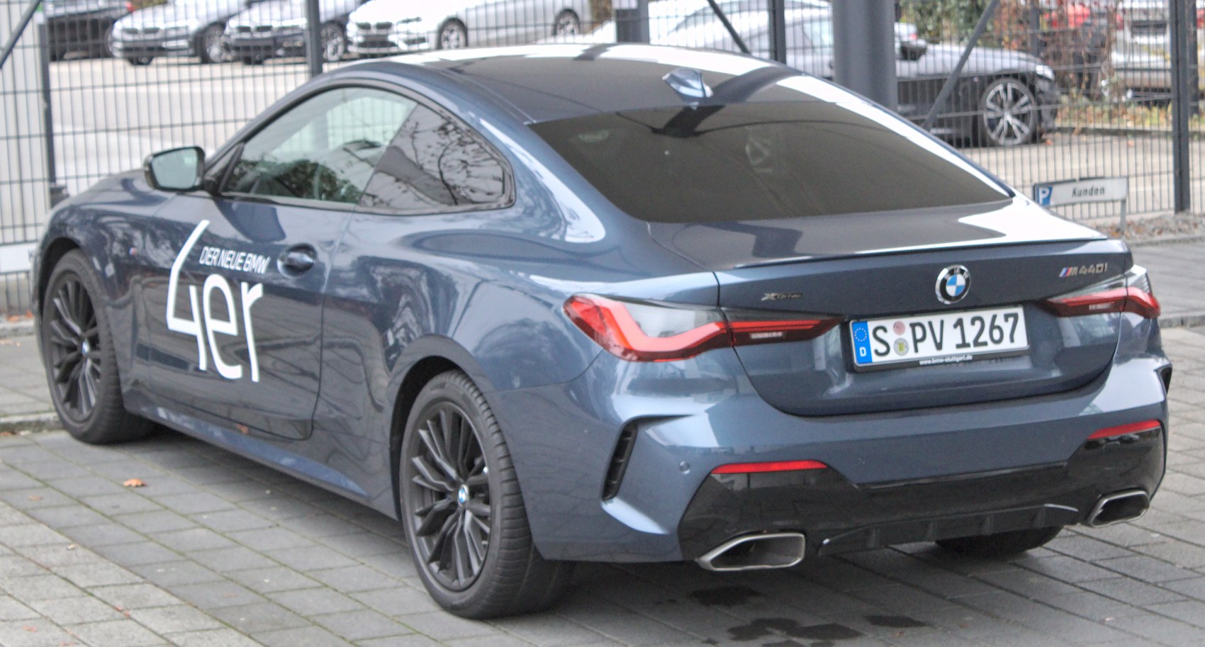 Rear and side view of a sleek coupe with tinted windows and dual exhausts