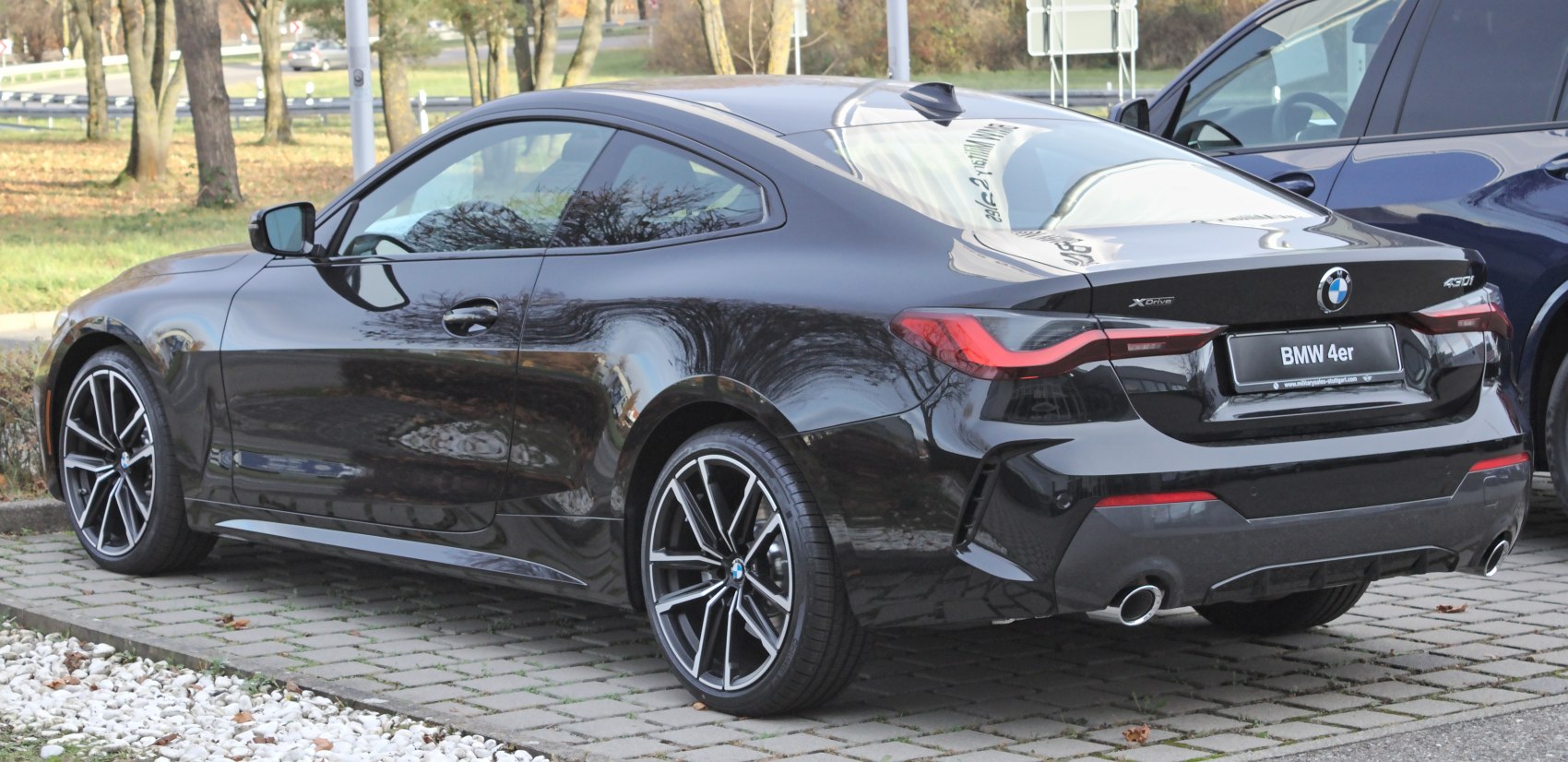 Black coupe rear side with alloy wheels and dual exhaust
