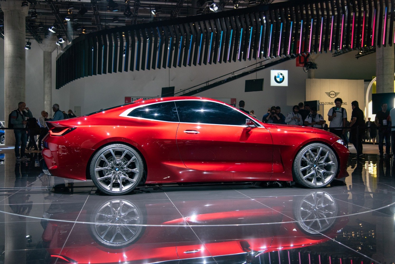 Sleek red coupe side profile with prominent alloy wheels