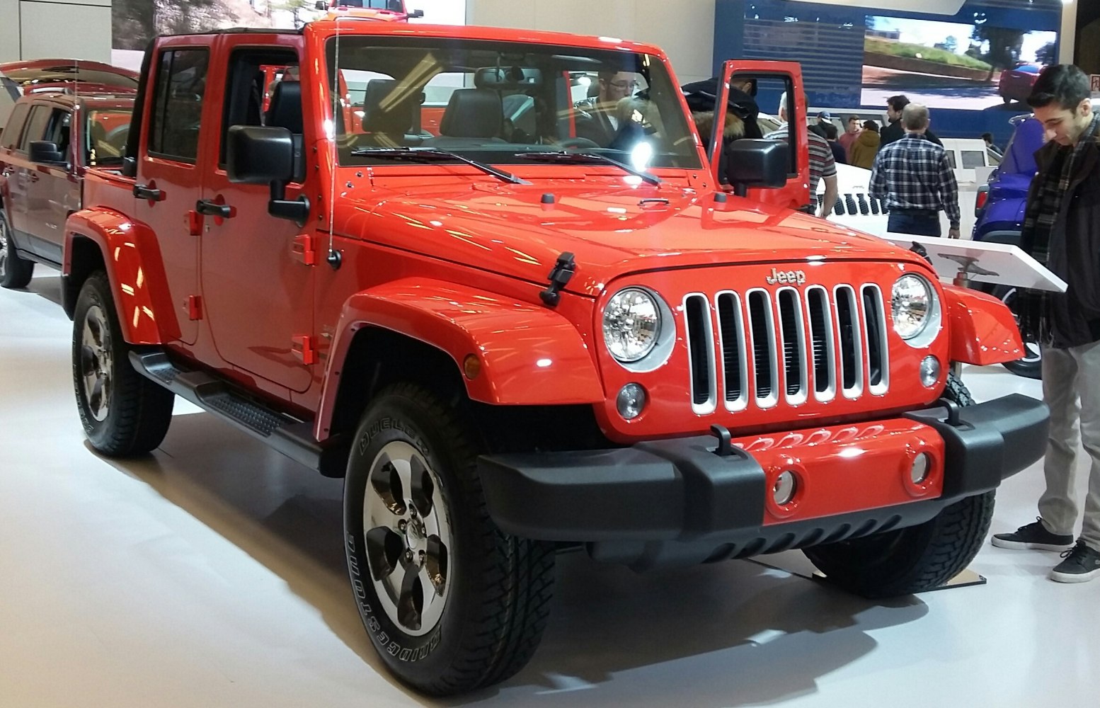 Red four-door SUV front side with round headlights and seven-slot grille