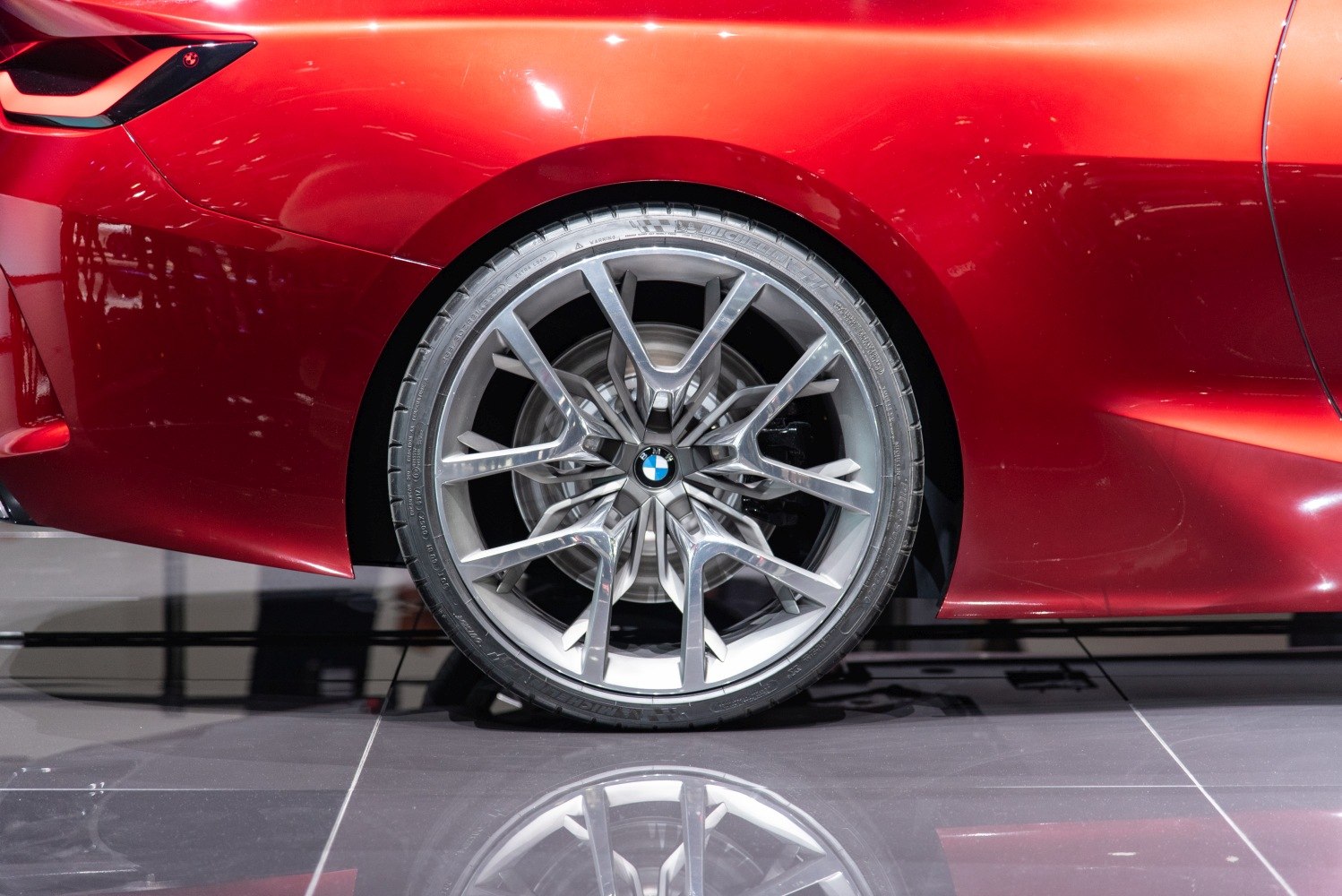 Close-up of intricate front wheel and alloy rim design on a car.