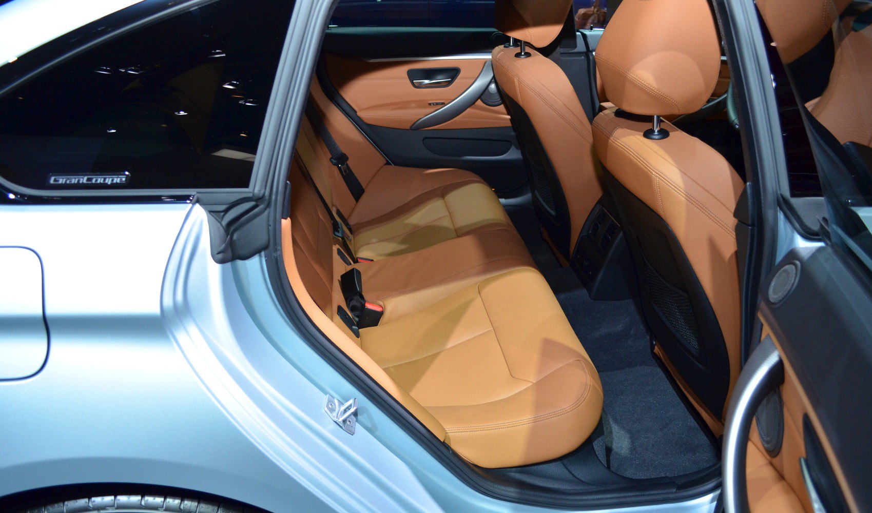 Rear passenger seats with tan leather upholstery and spacious legroom.