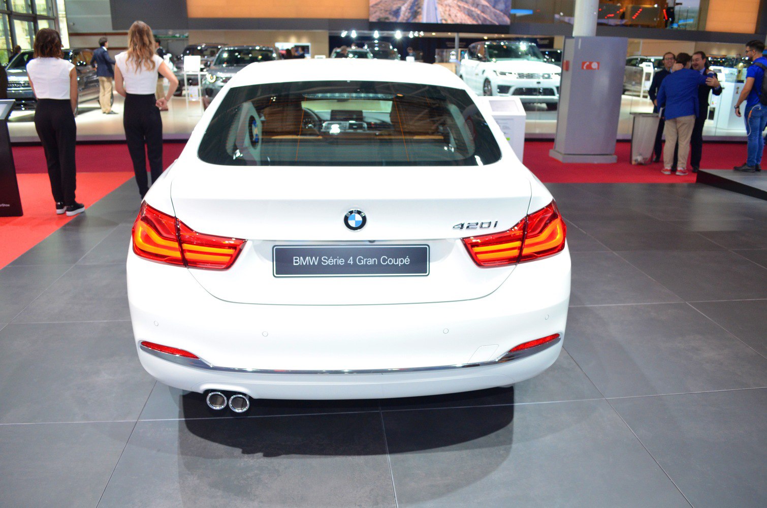 Rear view with illuminated tail lights and dual exhaust pipes