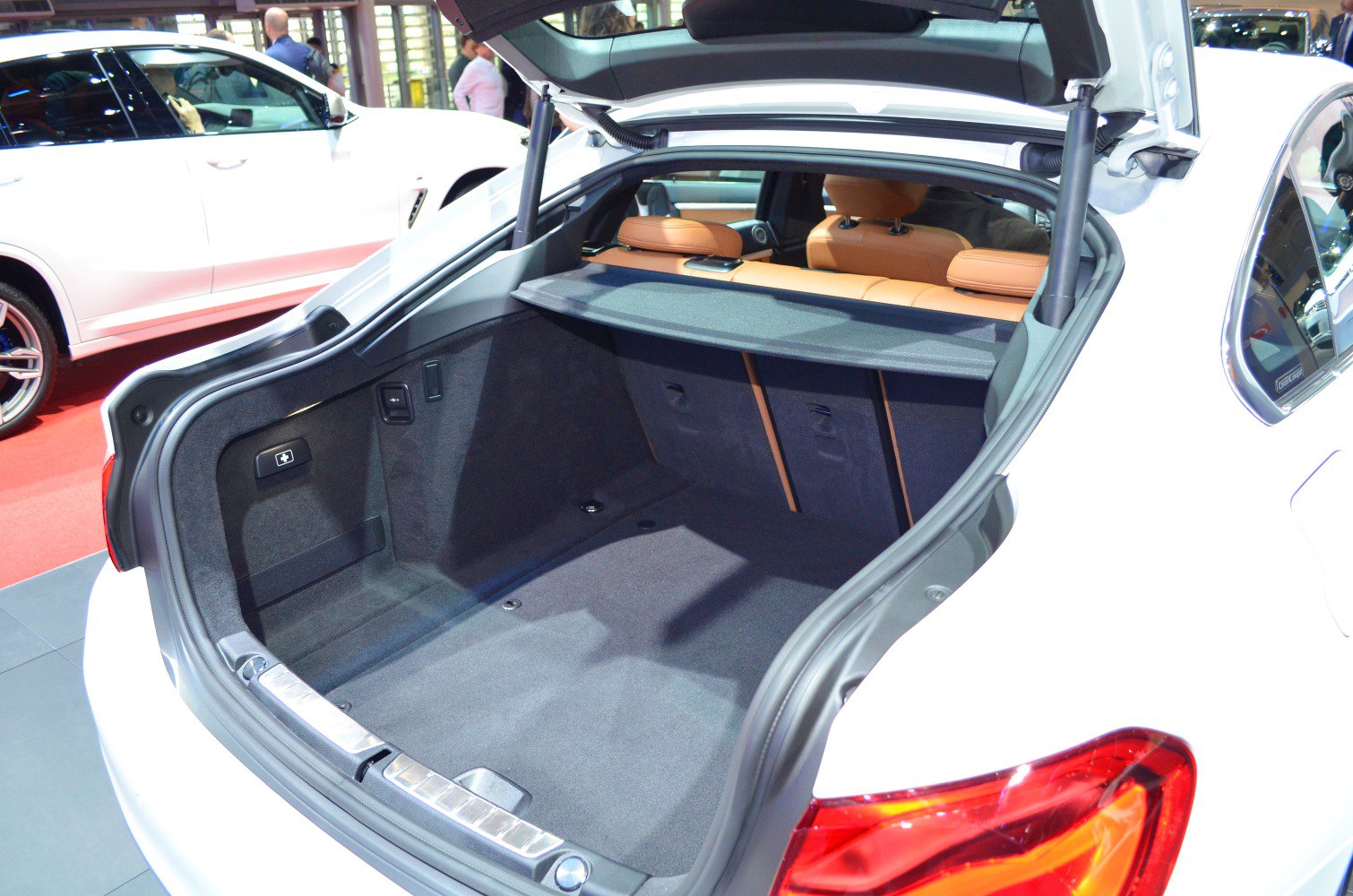 Spacious rear cargo area with protective cover and folded-down brown leather rear seats.