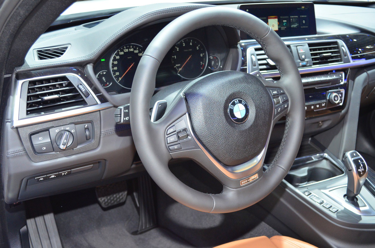 Steering wheel and dashboard controls in a luxury coupe interior