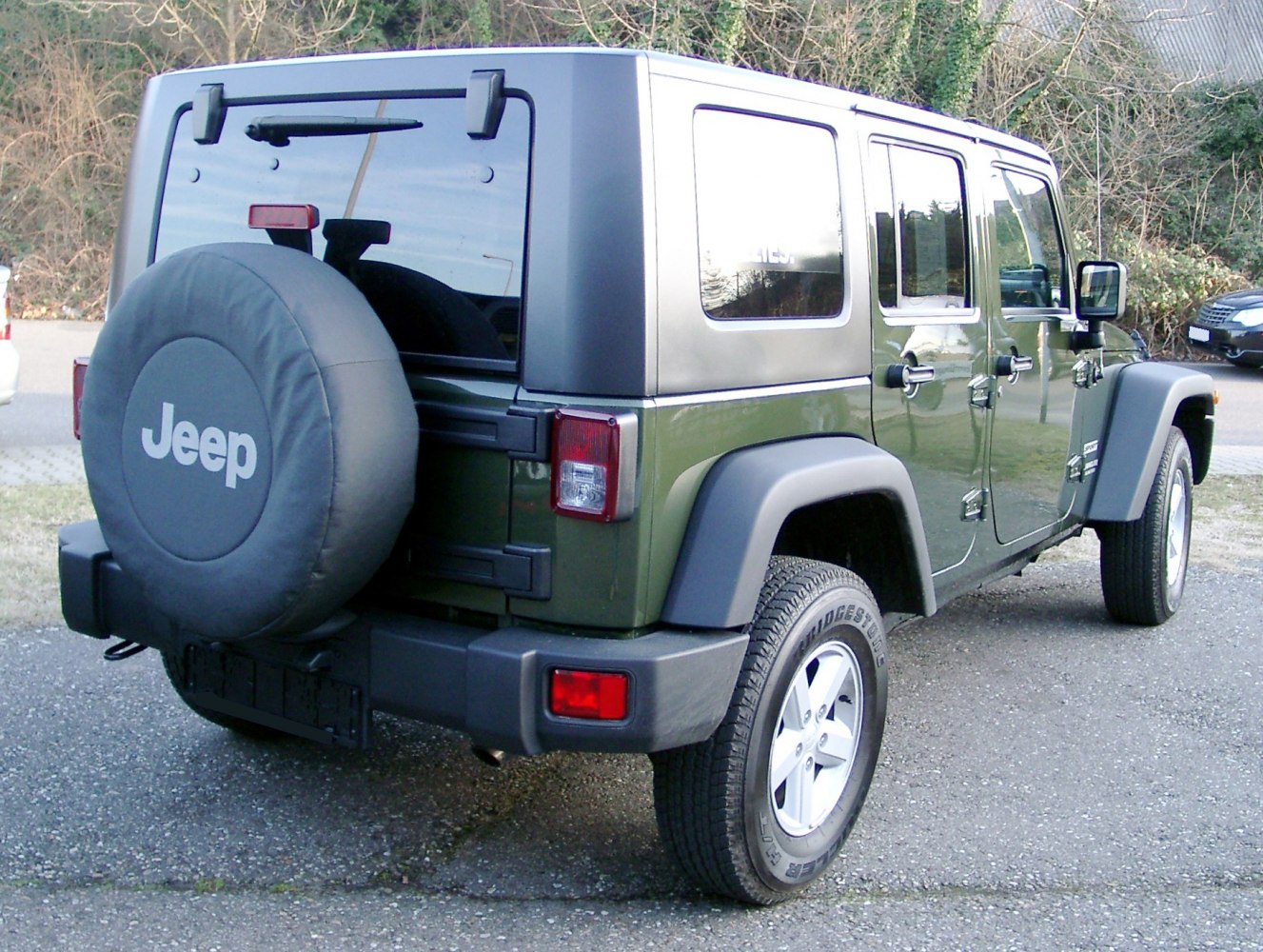 Rear view of Jeep Wrangler with spare tire and hardtop roof