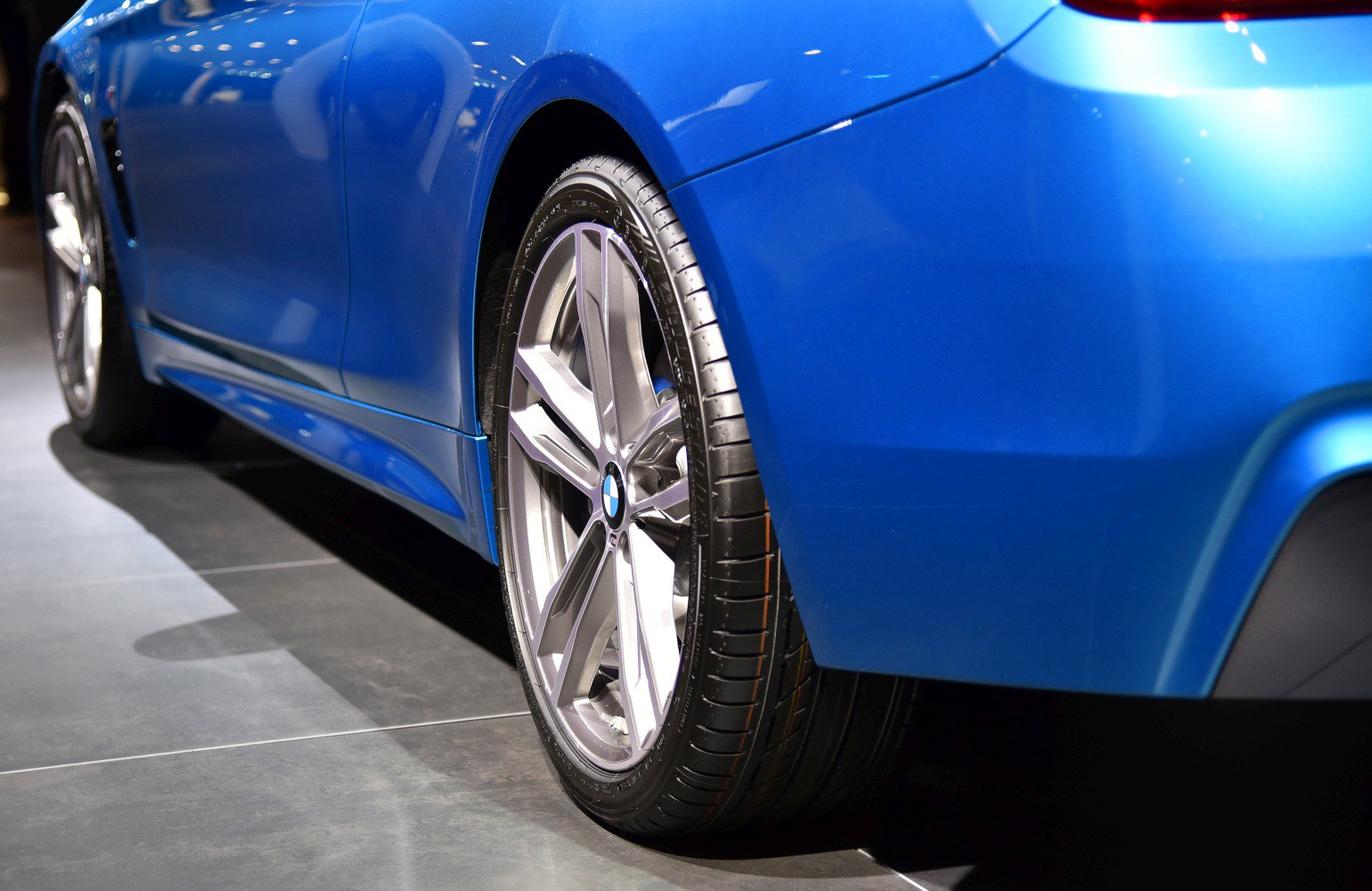 Silver alloy wheel and tire on blue BMW 4 Series Coupe