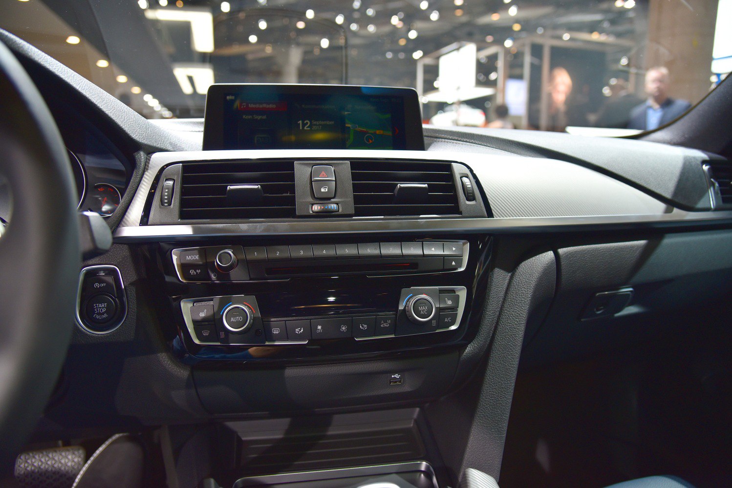 Center console and infotainment screen with climate control knobs and start stop button