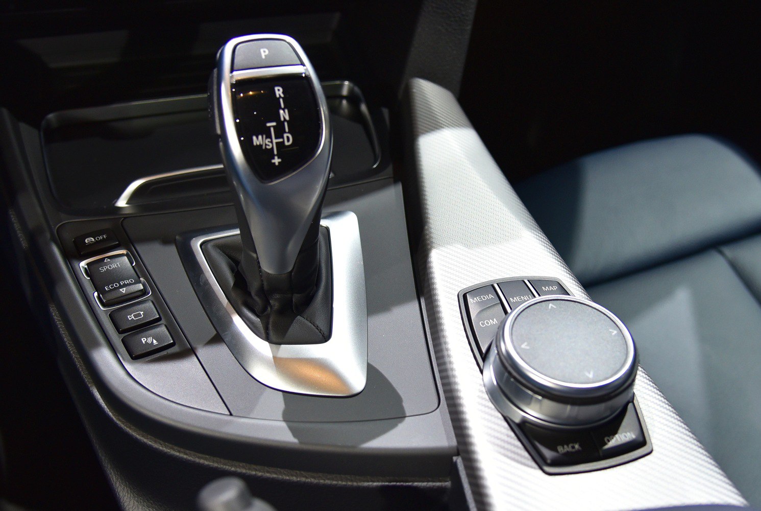 Automatic gear shift lever and multimedia control dial inside car interior