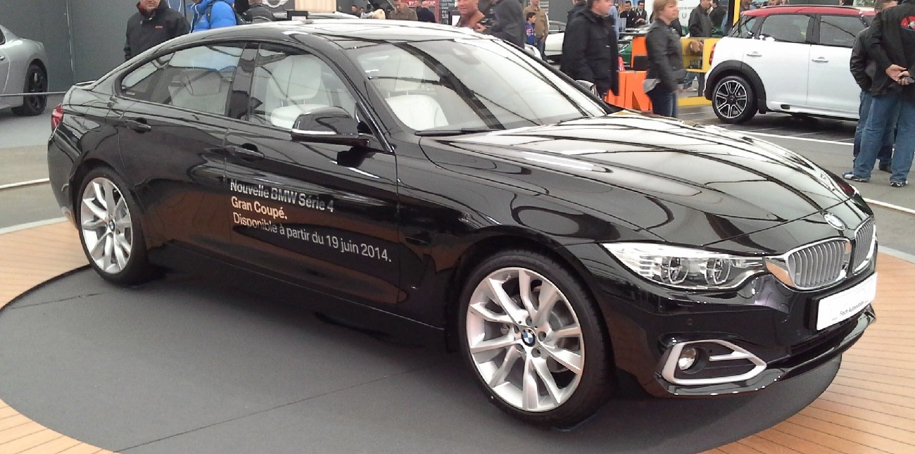 Front side view of sleek black luxury coupe with aerodynamic design.