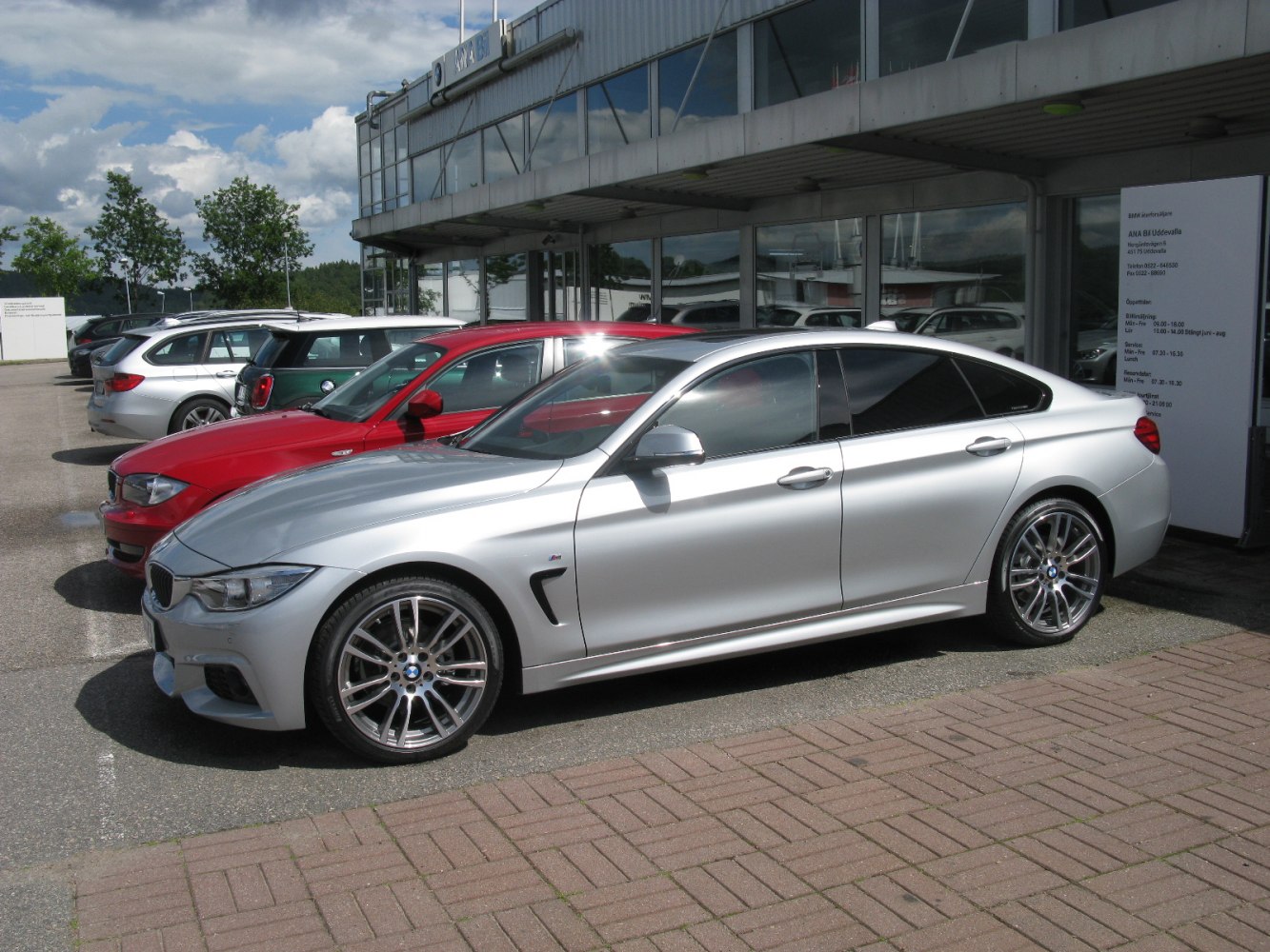 Silver sedan with sporty design and multi-spoke alloy wheels parked in front view