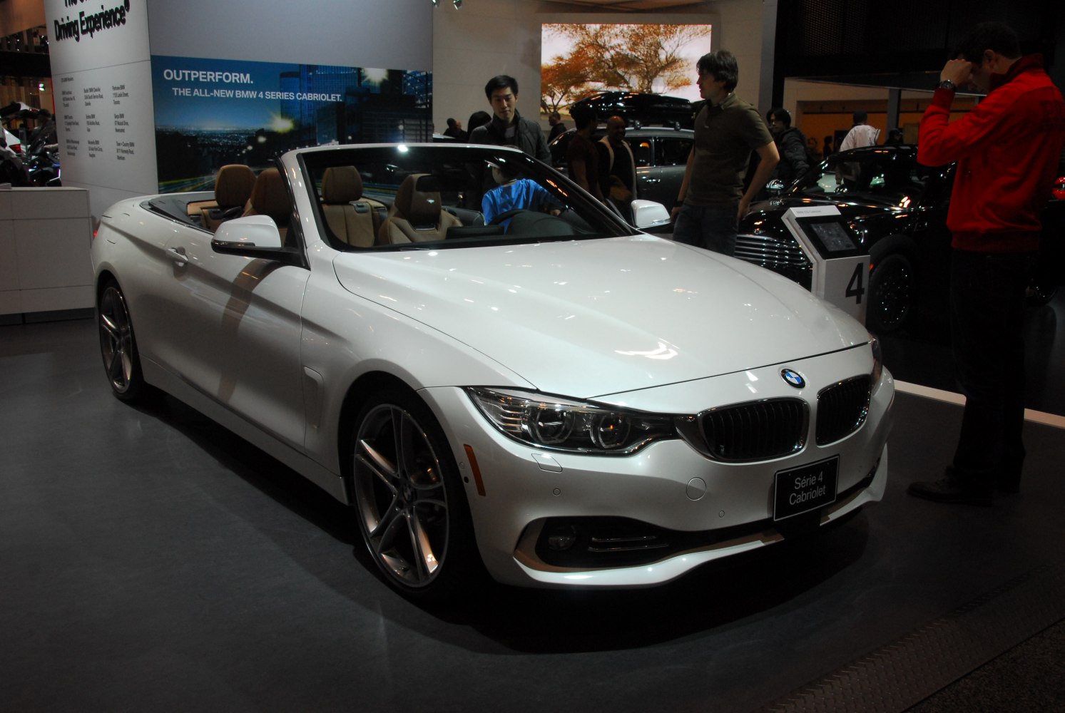White mid-size convertible with soft top down and leather interior