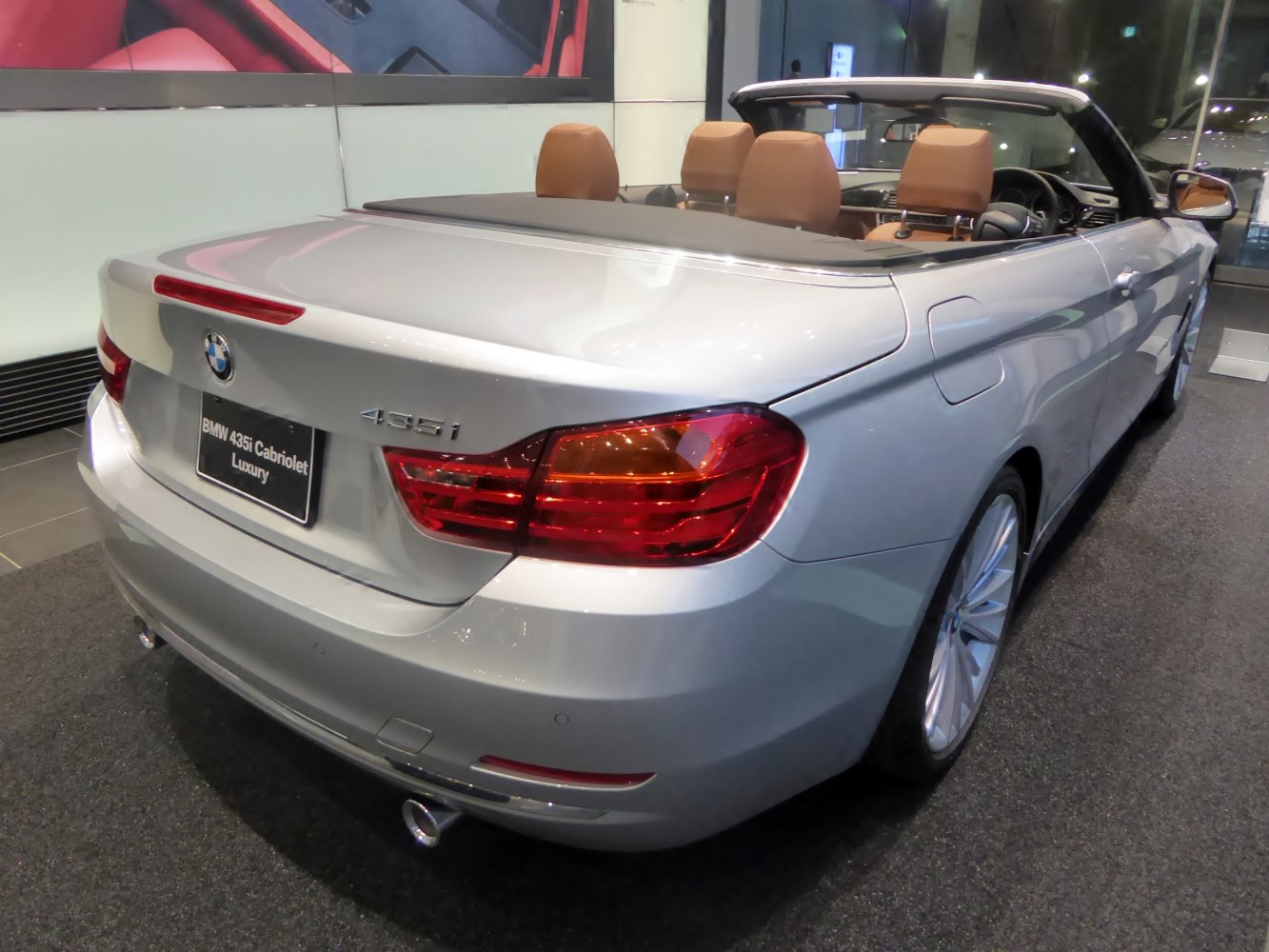 Rear view of luxury convertible with visible taillights and tan leather seats