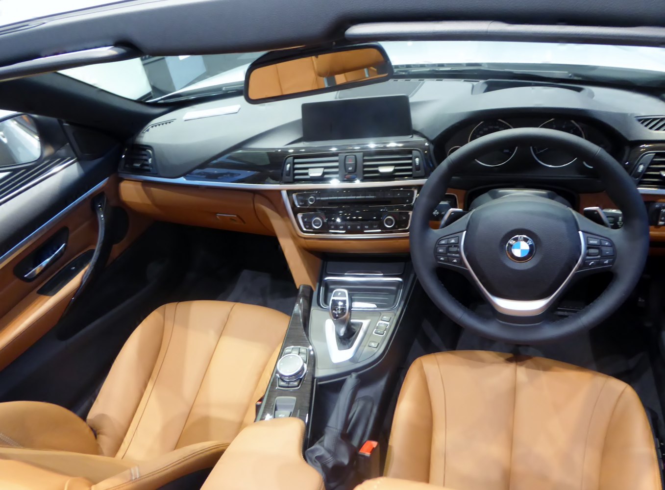 Tan leather seats and modern dashboard with infotainment and steering wheel controls