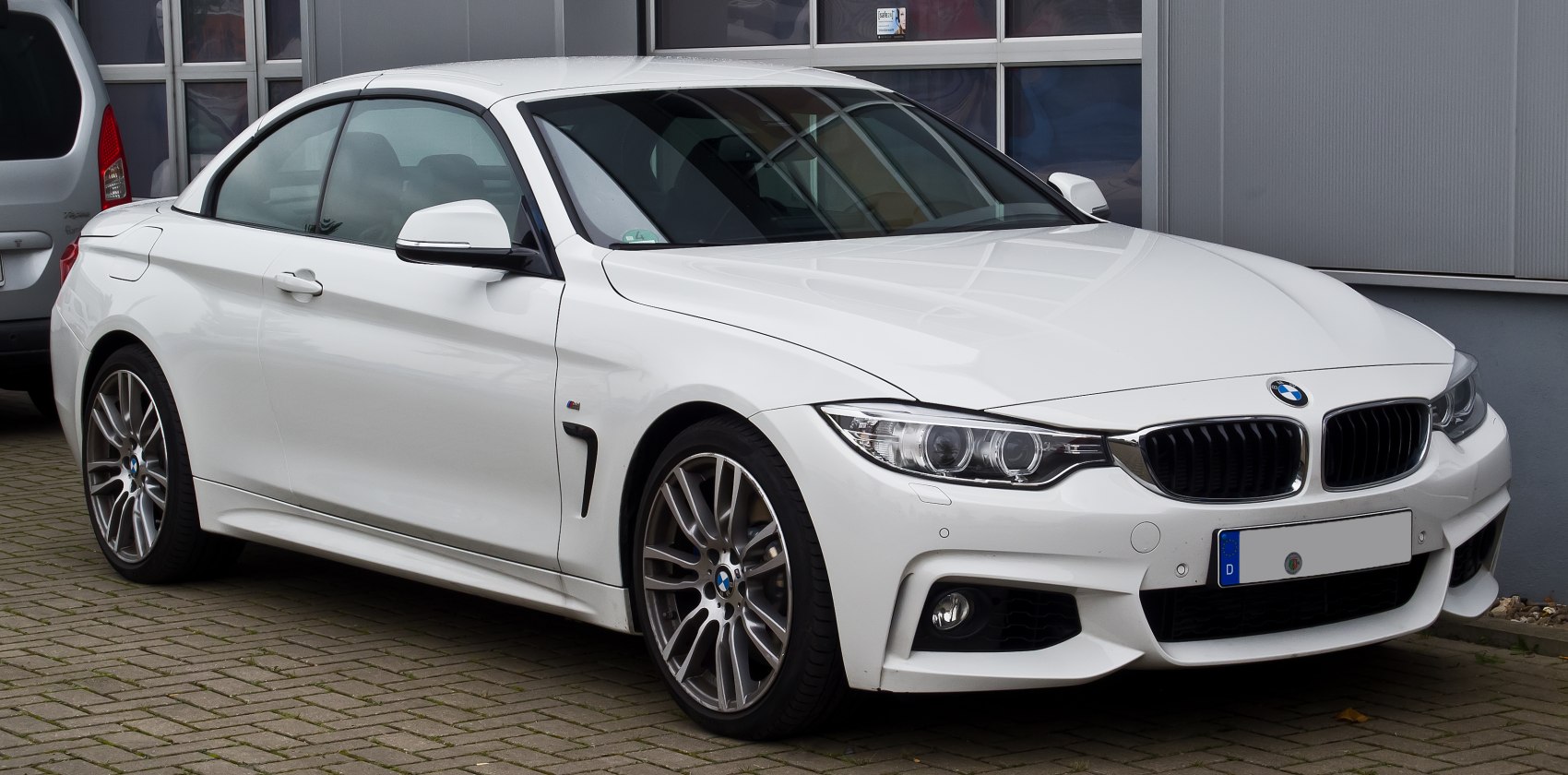 White luxury convertible coupe with dual headlights and sporty alloy wheels.