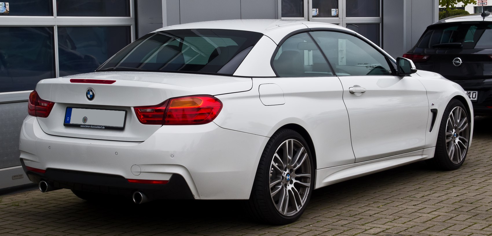 White convertible hardtop rear view with dual exhaust