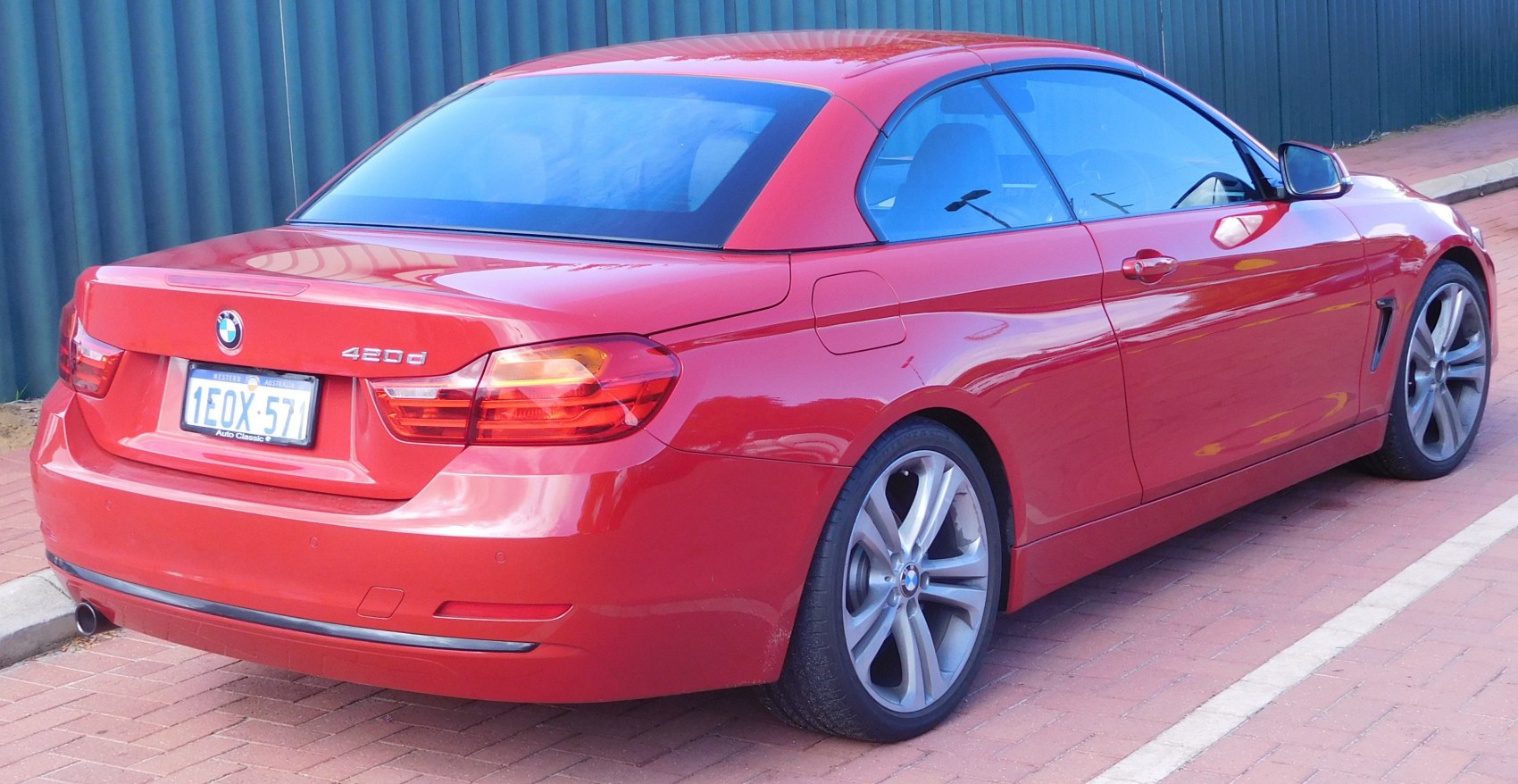 Red BMW convertible rear with taillights and alloy wheels
