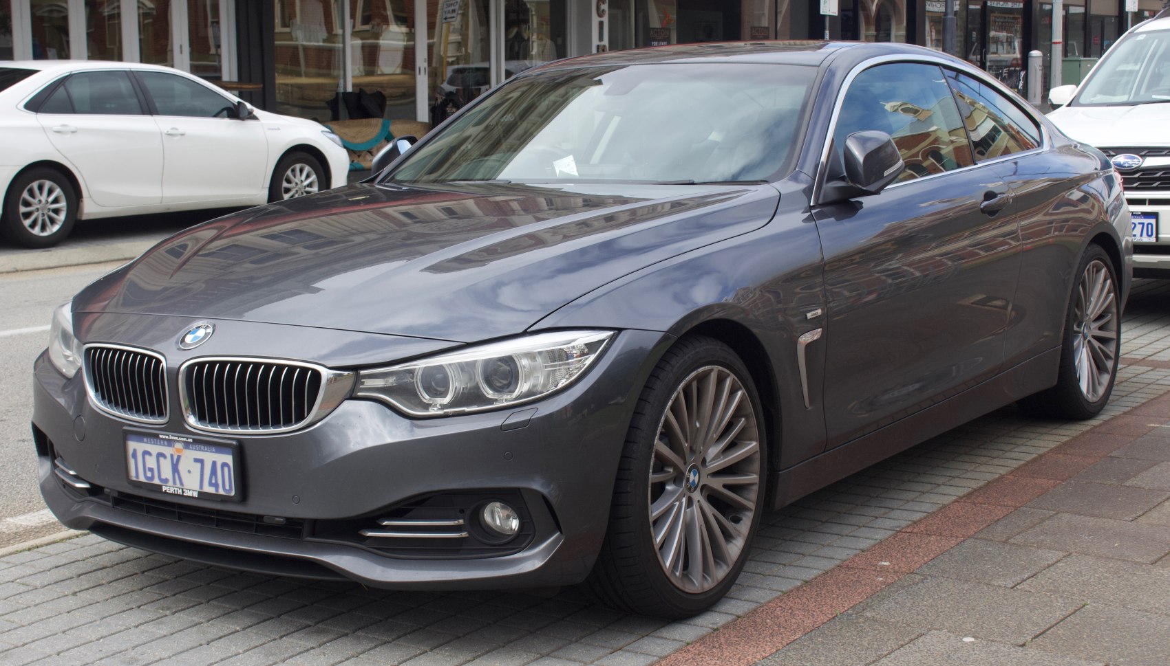 Front and side view of a coupe with dual headlights and kidney grille