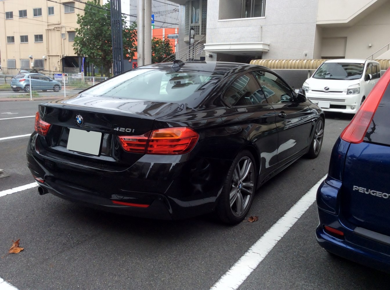 Rear view of a black coupe with prominent taillights and sporty design