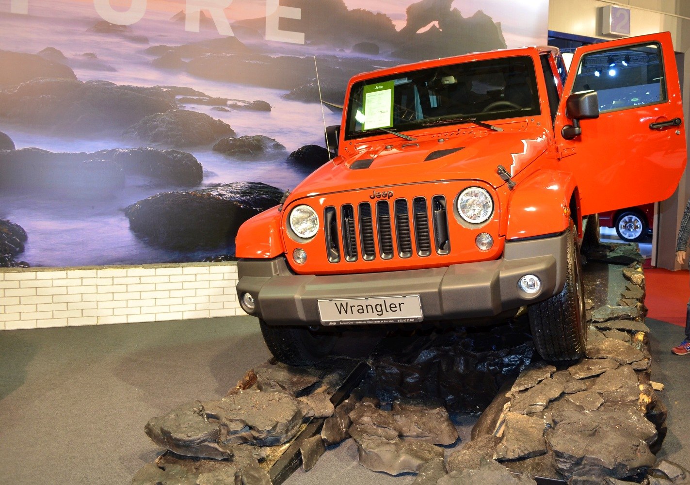 Rugged front grille and open-door off-road SUV on rocky terrain