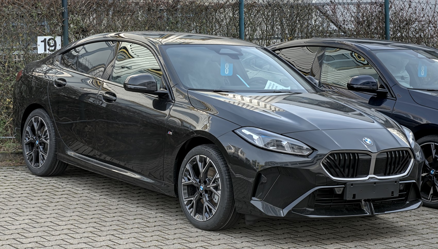 Sleek front end and side profile of a modern four-door coupe