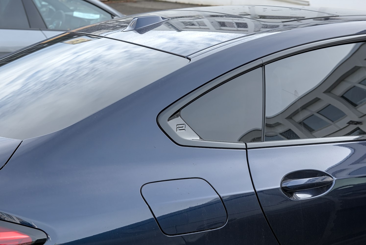 Rear side window, fuel door, and shark fin antenna on a coupe