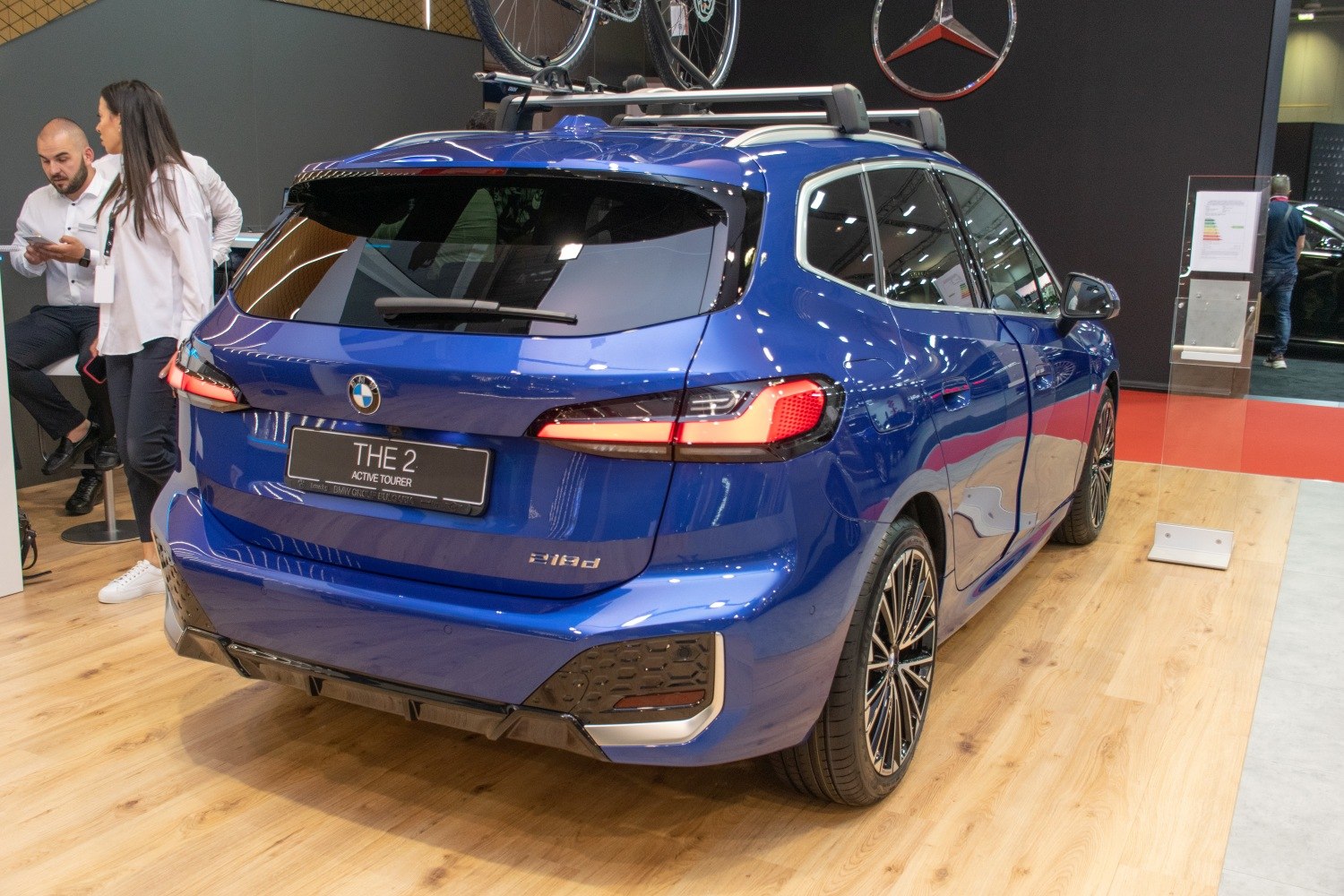 Rear view of blue vehicle with sleek tail lights and roof bike rack