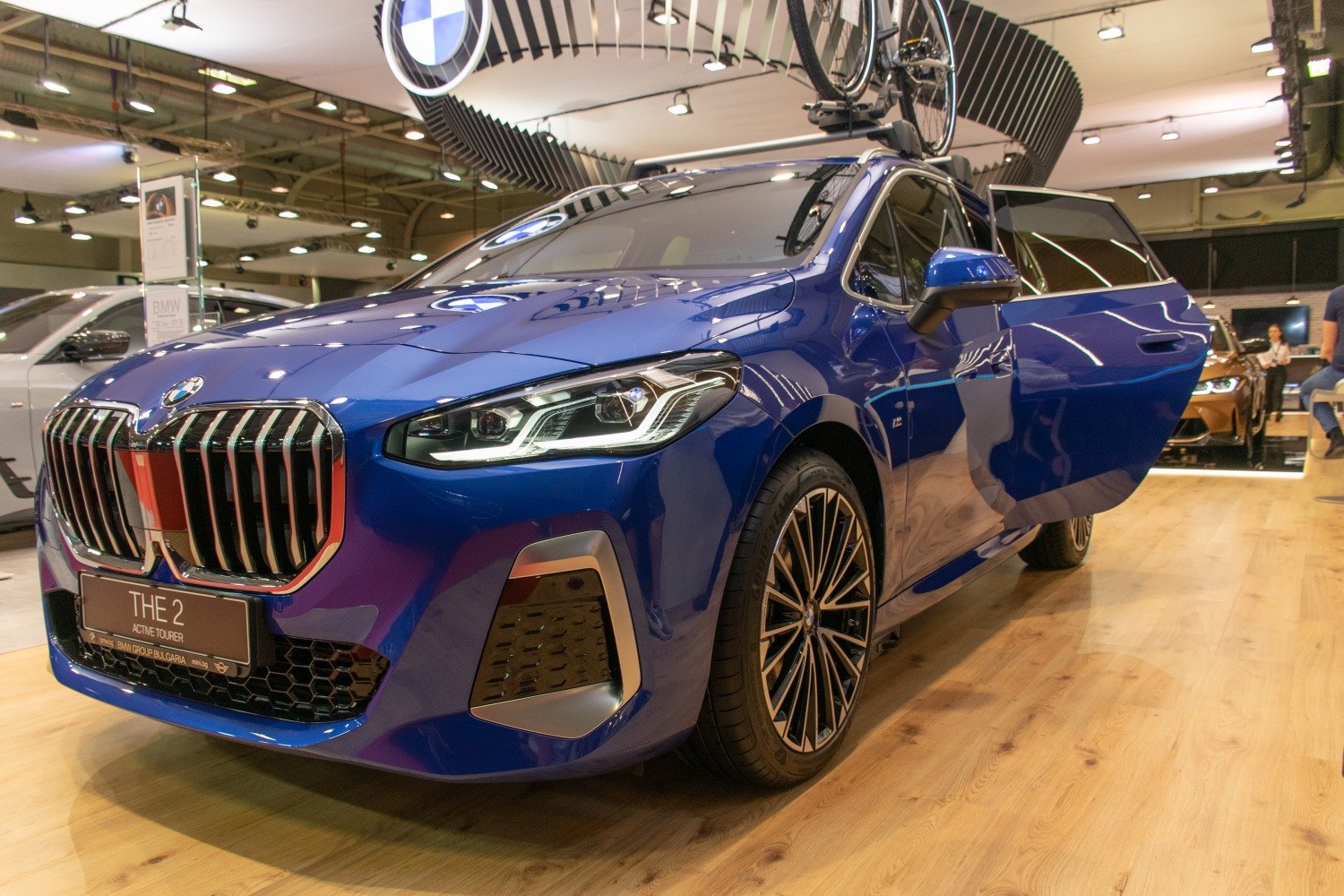 Front view of blue vehicle with distinctive grille and open front door