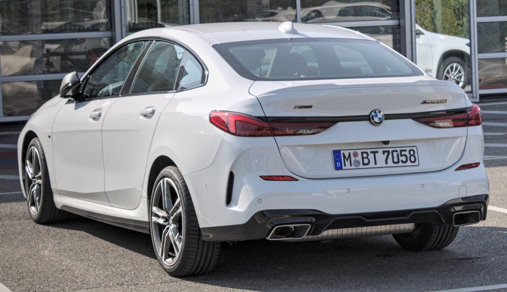 Rear view of a white sedan with sleek taillights and dual exhaust outlets