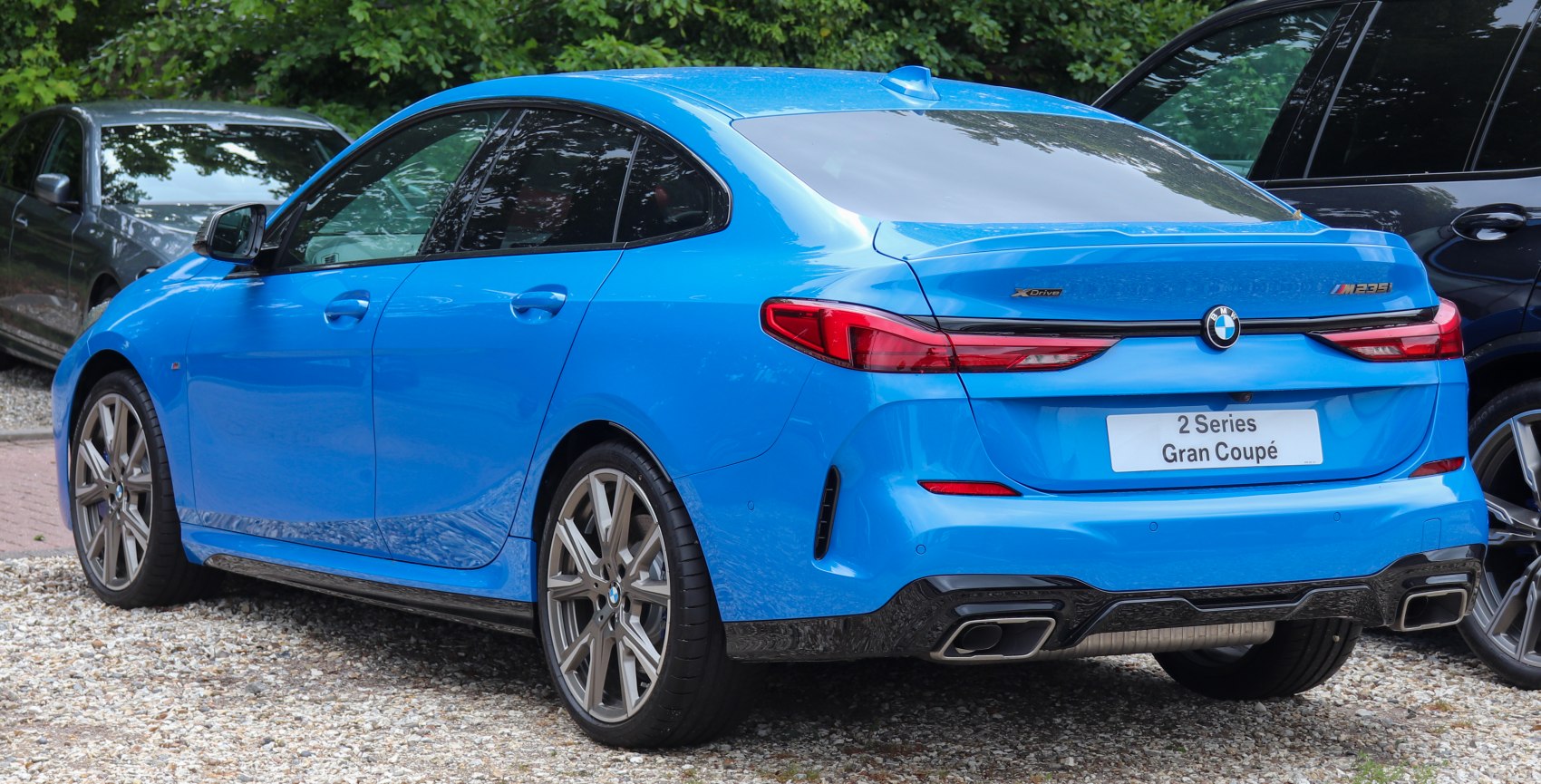 Rear view of sporty blue Gran Coupe with dual exhausts and sleek tail lights