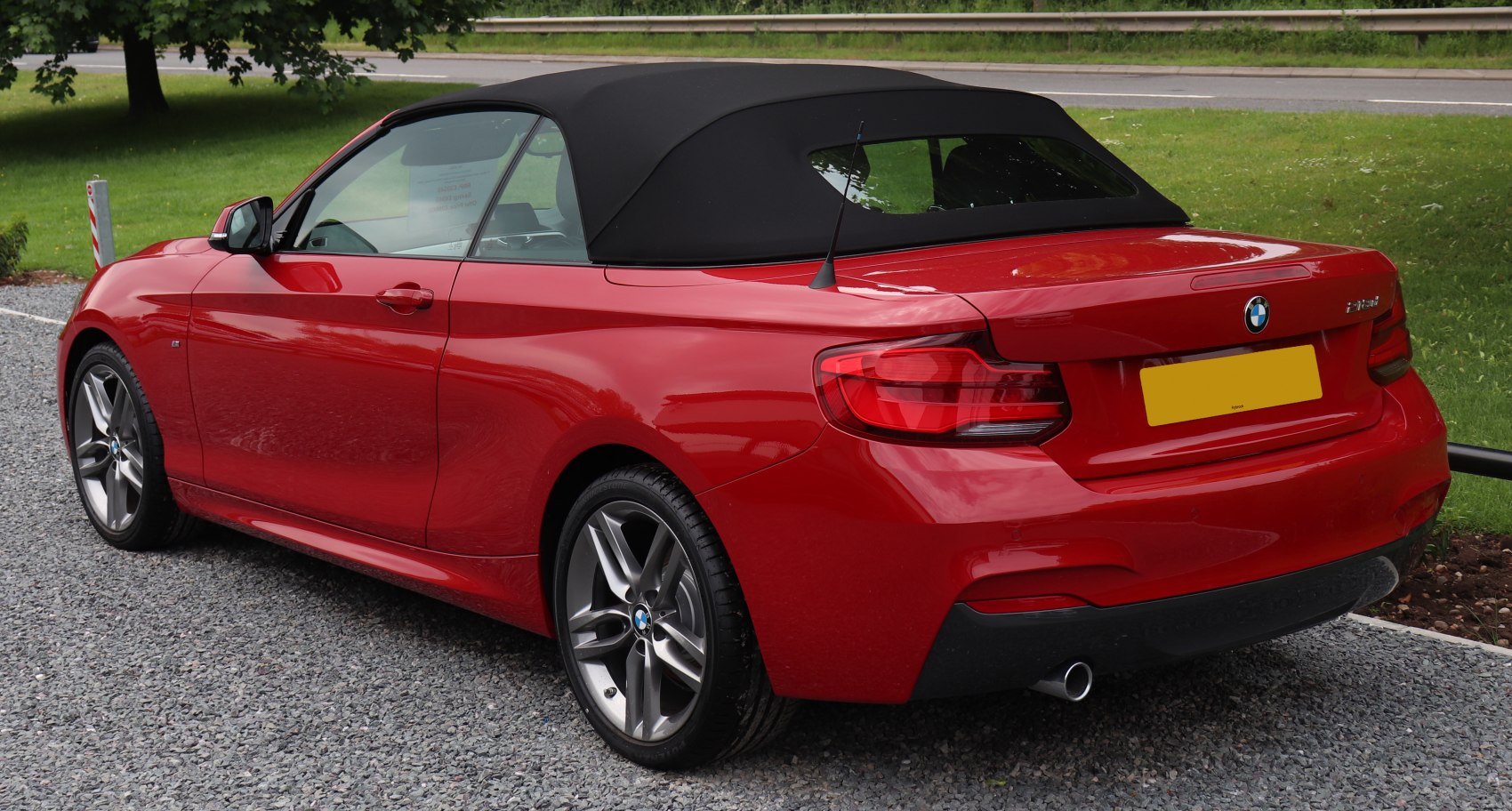 Red convertible with black soft top and rear view