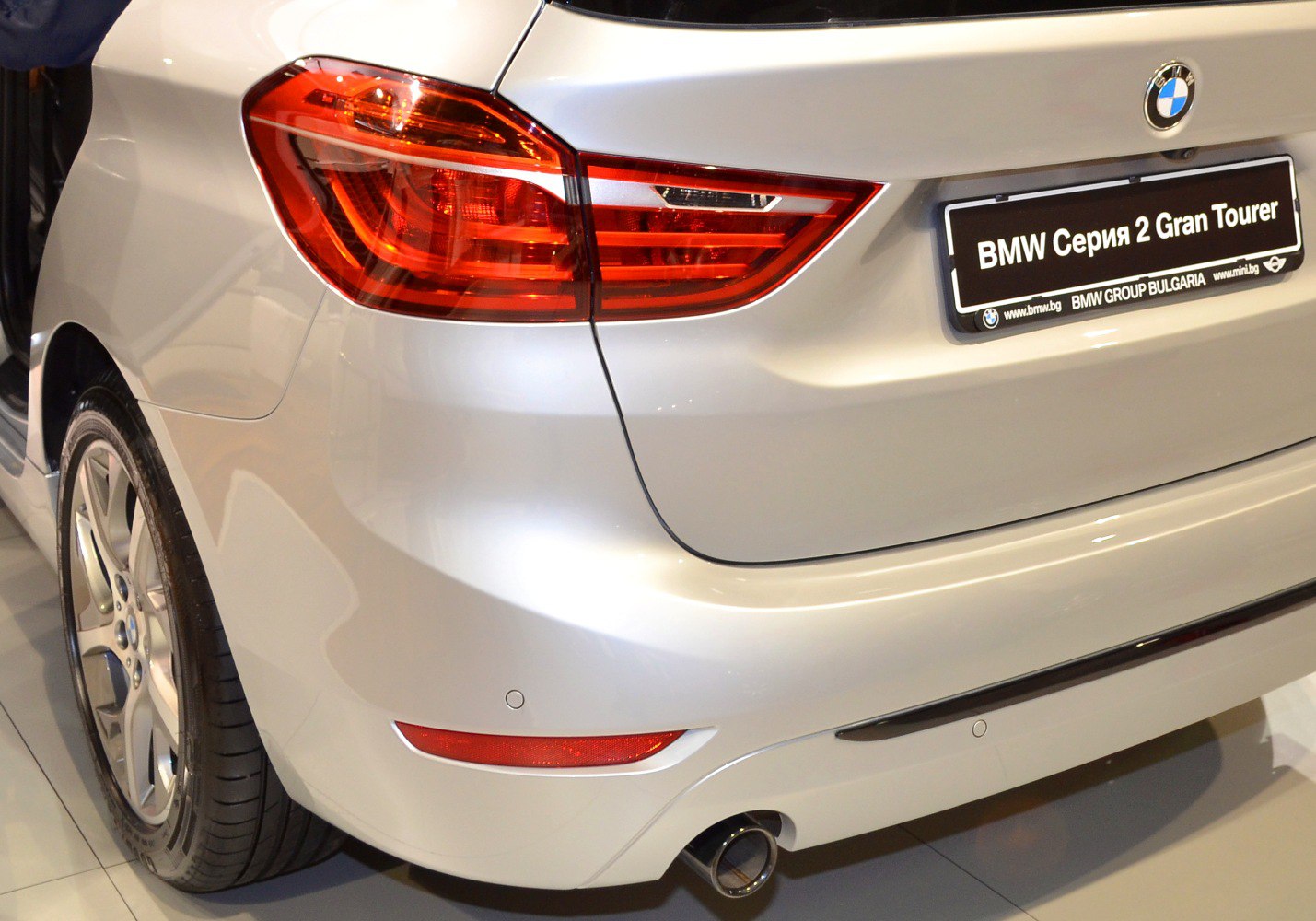Rear tail light, exhaust pipe, bumper, and wheel visible