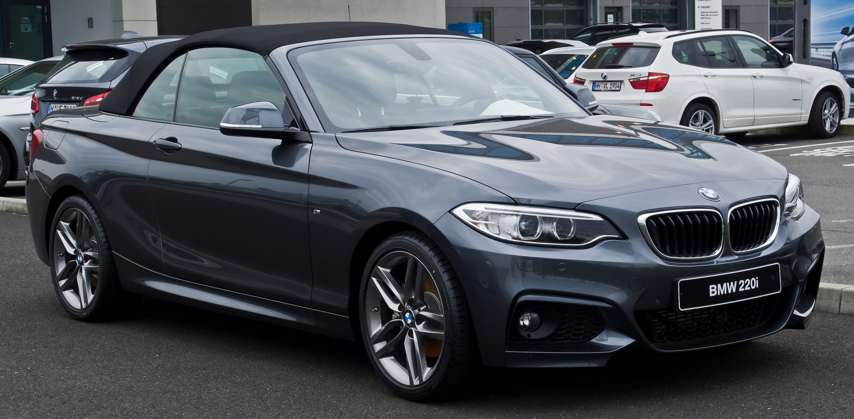 Sporty front side view of a convertible with soft top roof and distinctive grille