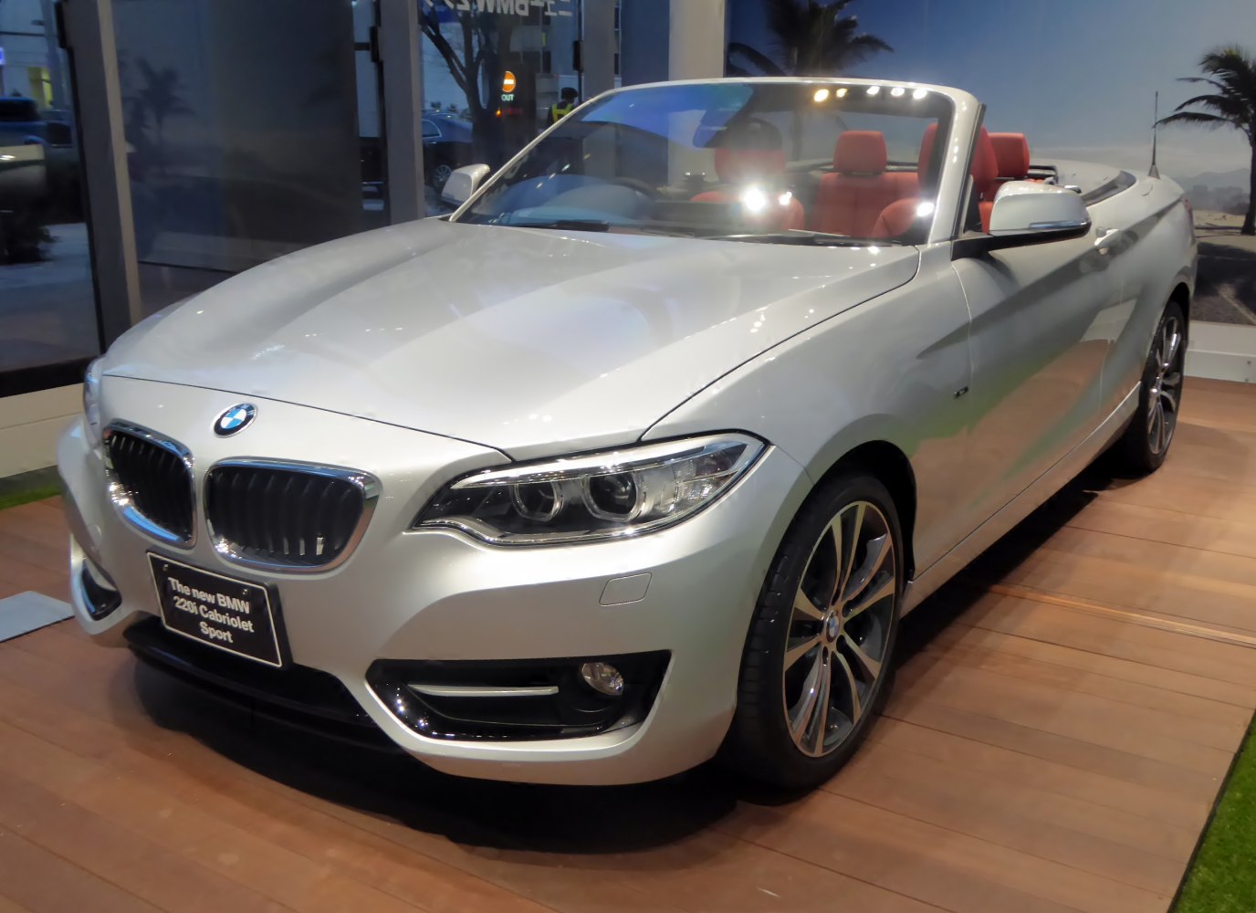 Convertible front view with distinctive grille and headlights, red seats visible