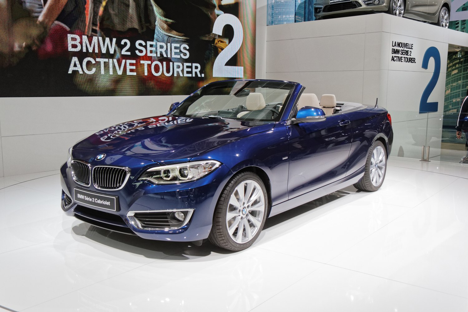 Blue convertible with beige leather interior and sleek design.
