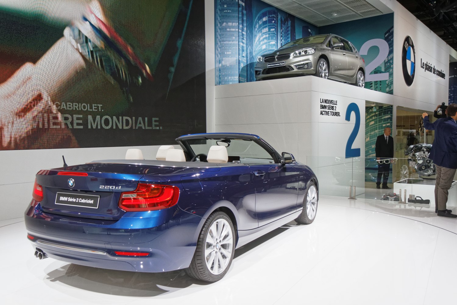 Rear and side view of a blue convertible with white interior