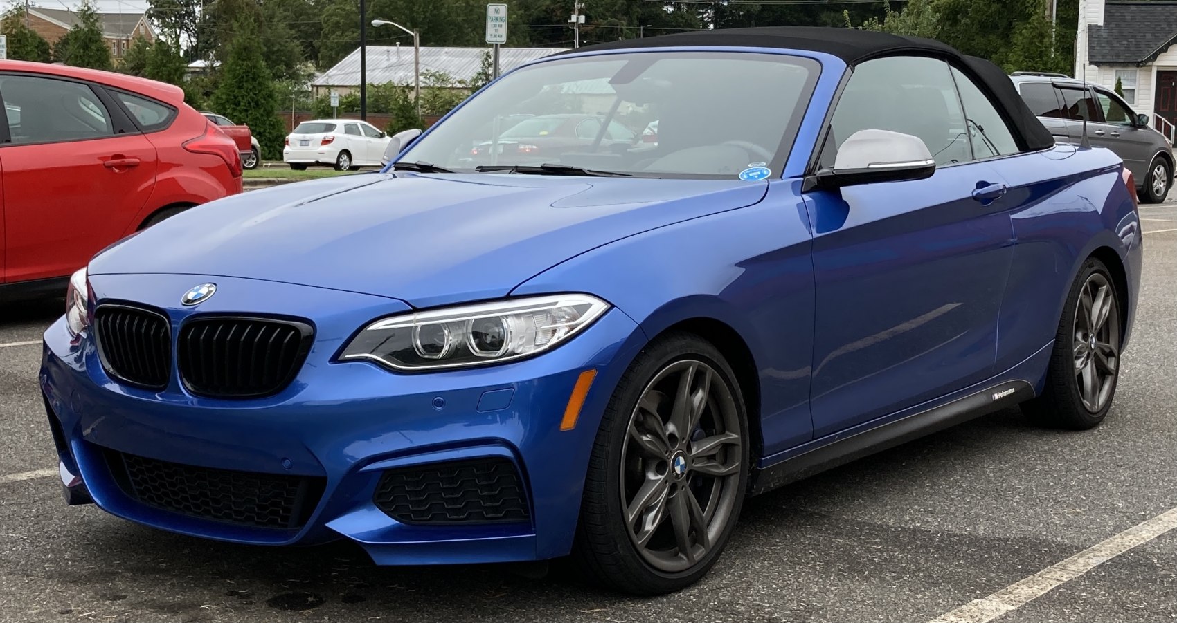 Blue convertible with black soft top, front side view, sporty alloy wheels