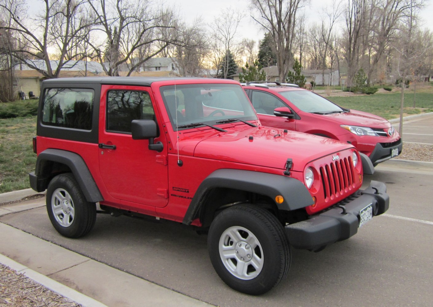 Red two-door SUV with black hardtop and off-road tires