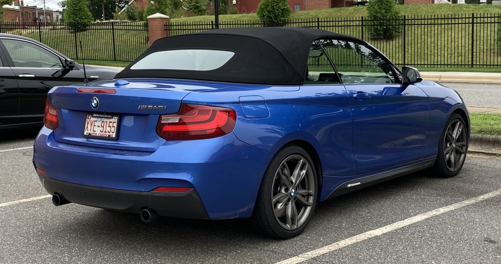 Rear view of blue convertible with black soft top and dual exhaust