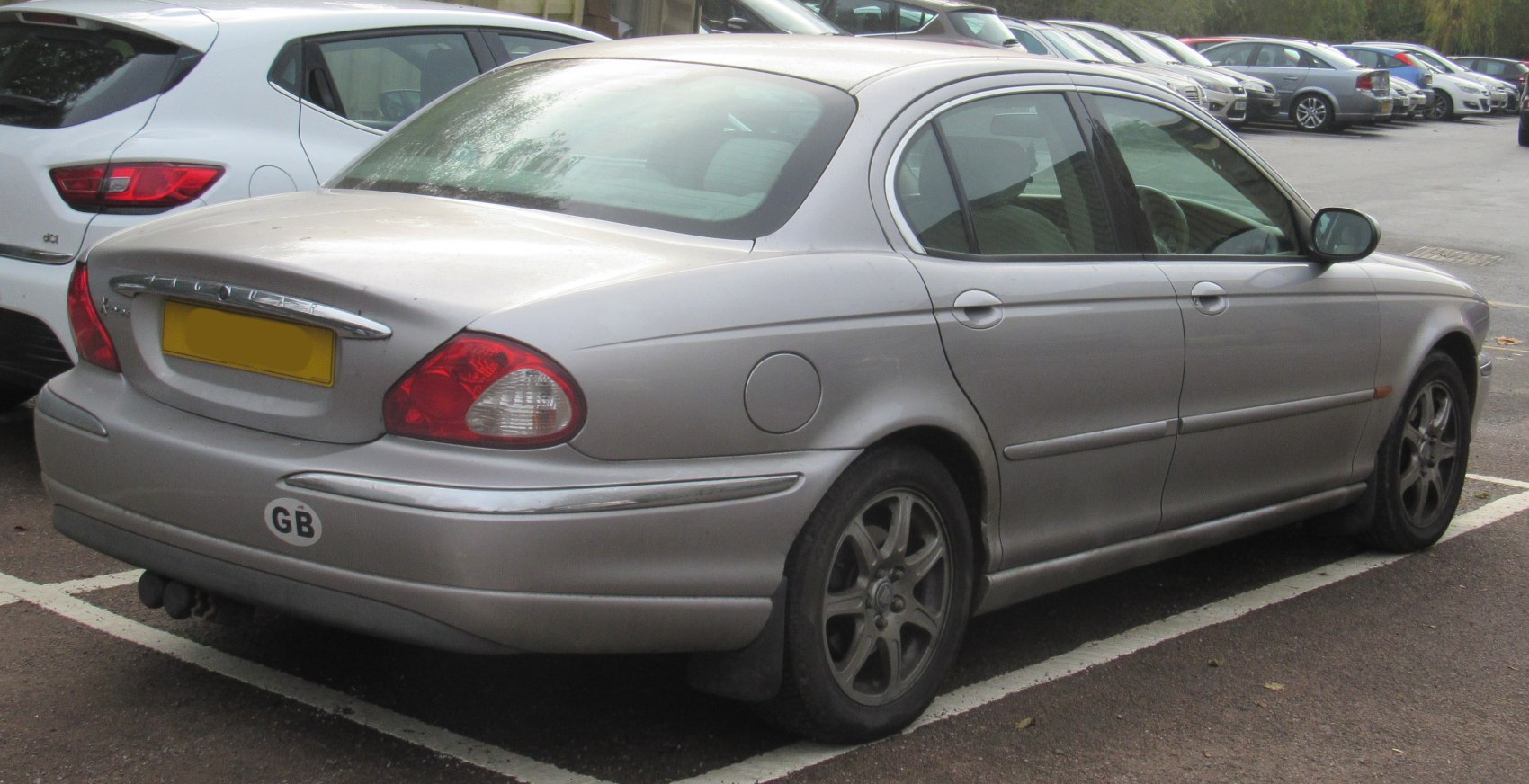 Silver sedan rear side with distinct tail lights and alloy wheels