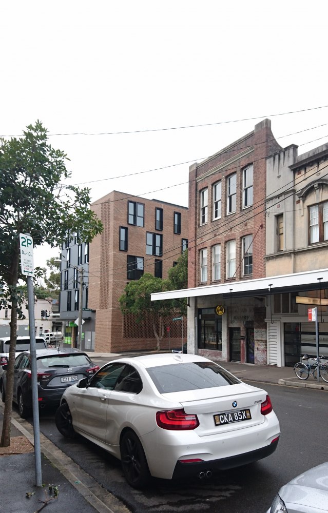 Rear view of white coupe with twin exhausts parked on city street