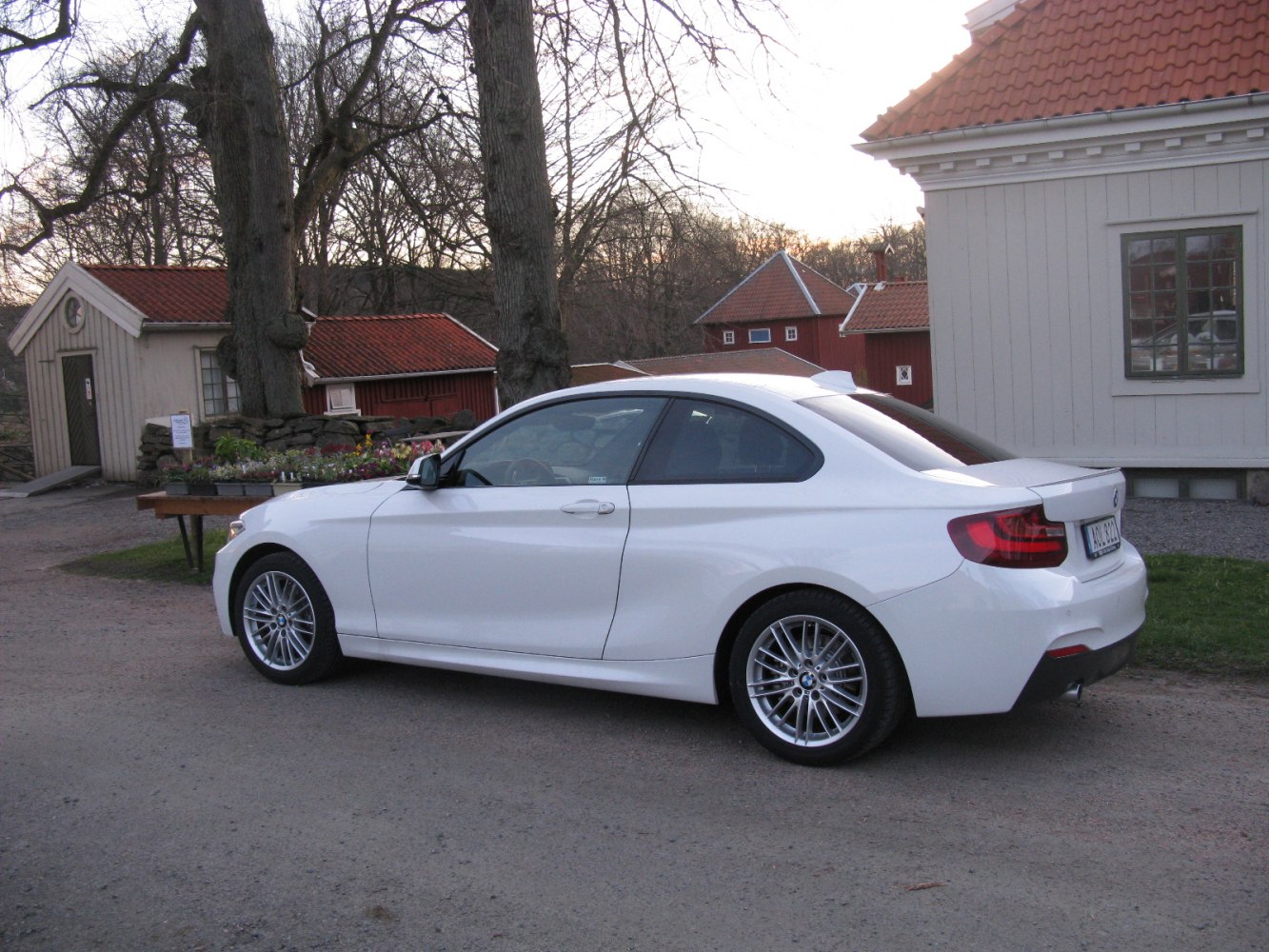 White two-door coupe rear and side profile with alloy wheels