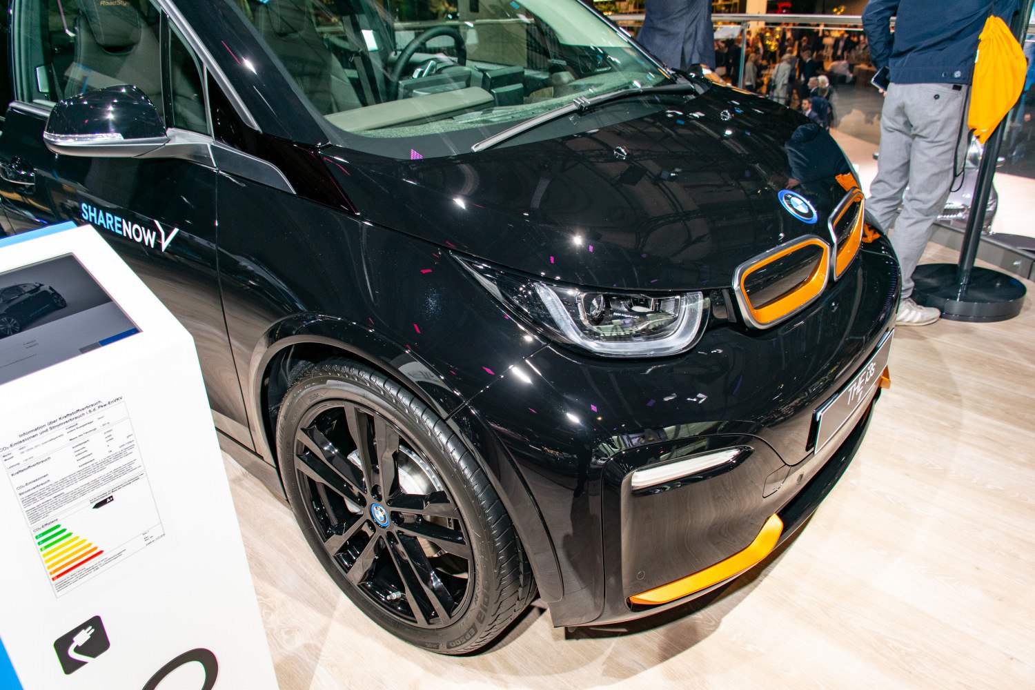 Glossy black BMW front with orange accents and detailed front wheel