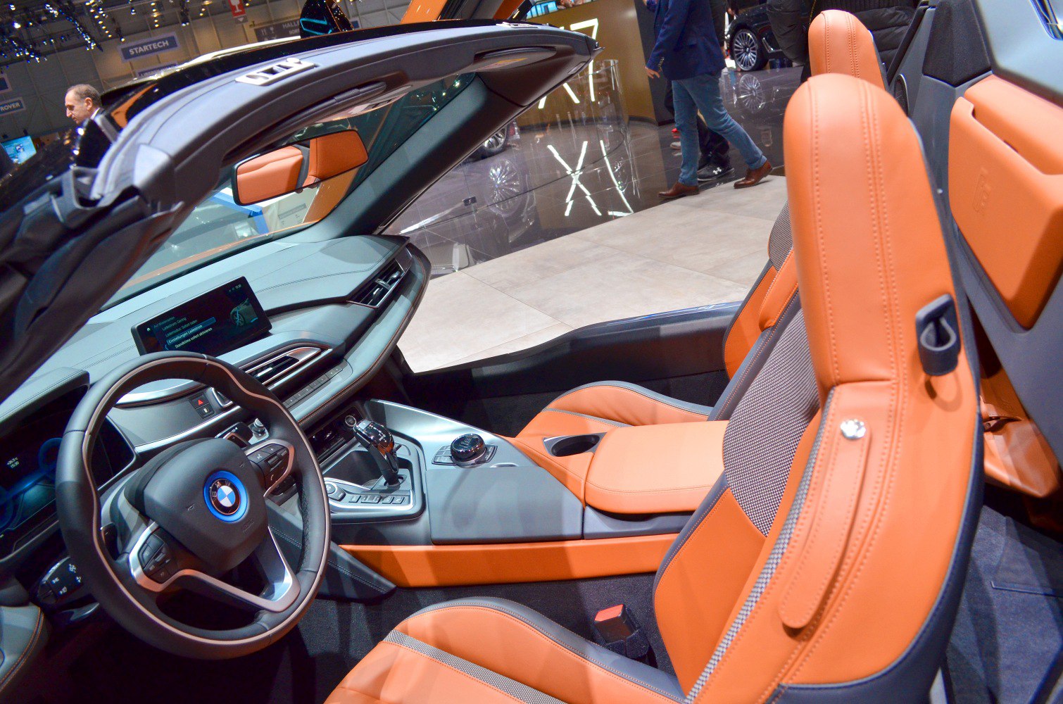 Convertible car interior with orange leather seats and advanced dashboard