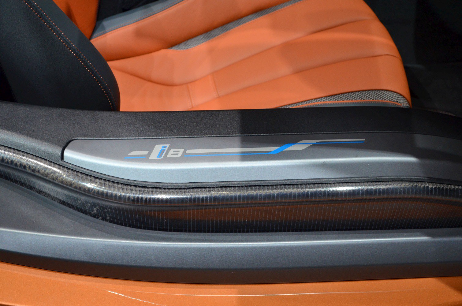 Interior door sill with carbon fiber trim and orange leather seat