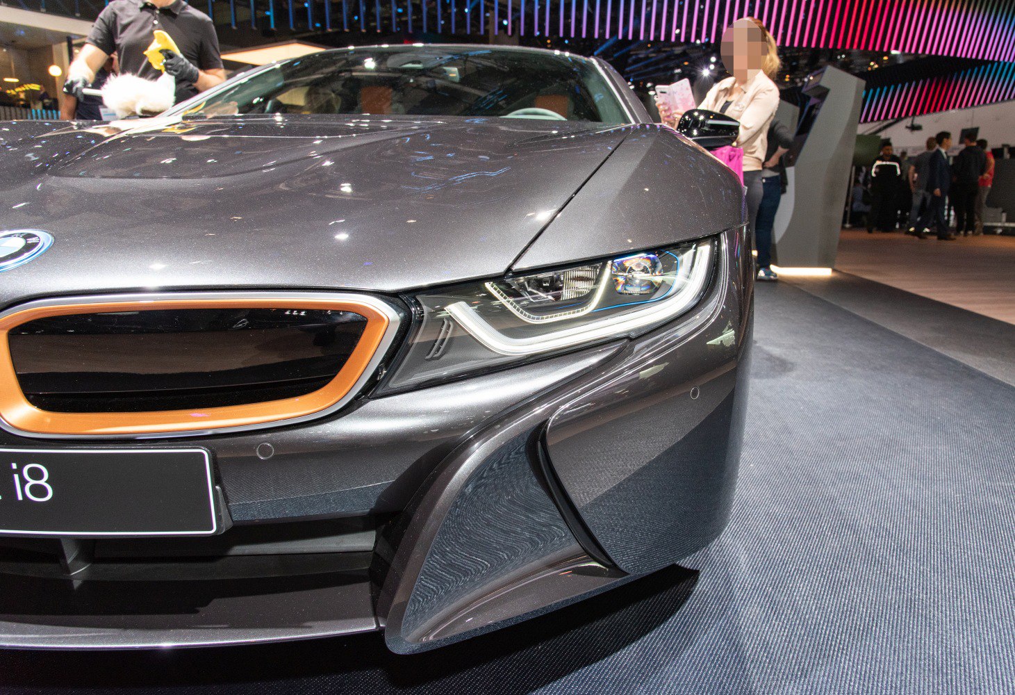 Front LED headlight and black grille with orange outline on sleek car front