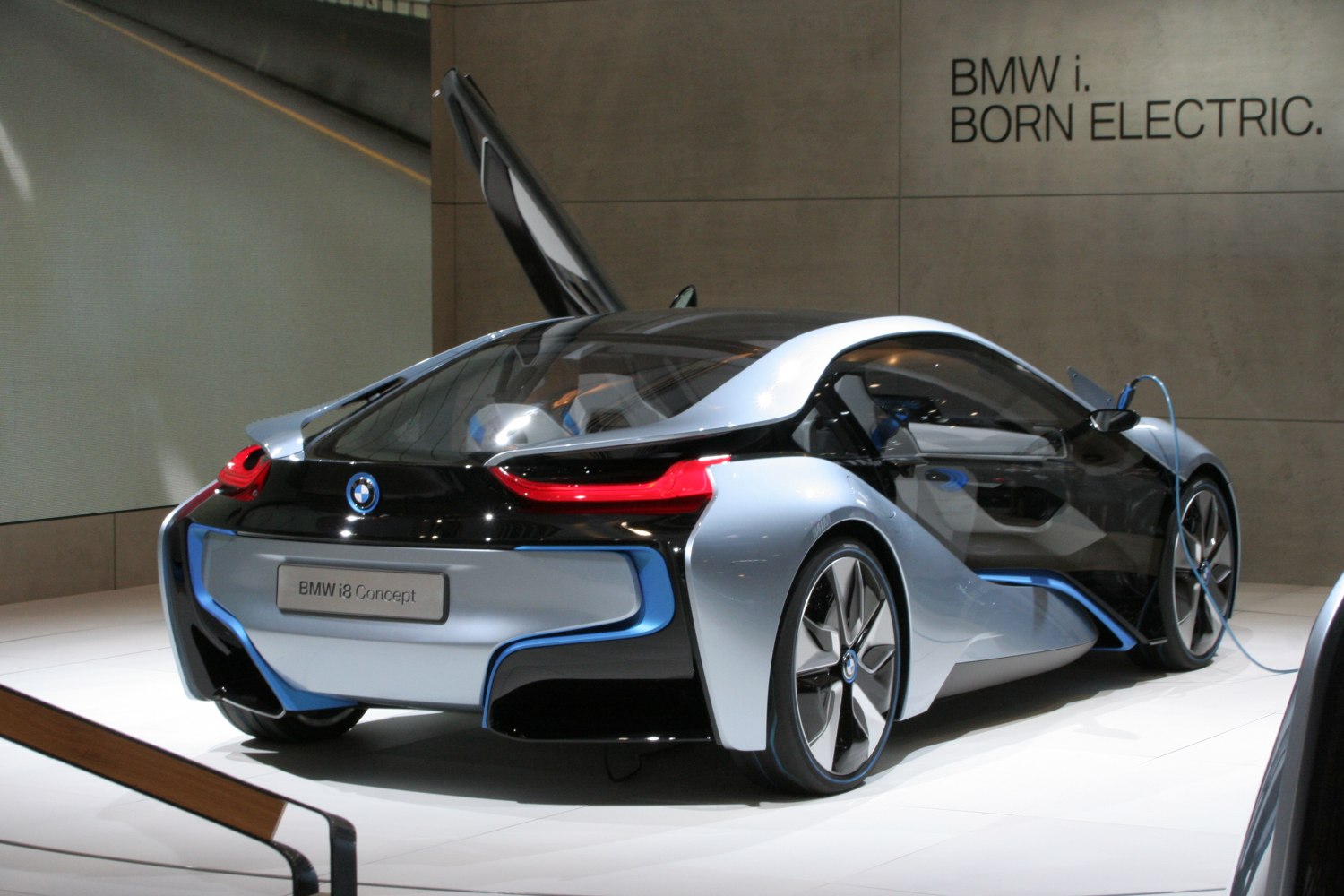Rear view of sleek coupe with gullwing door and electric charging port