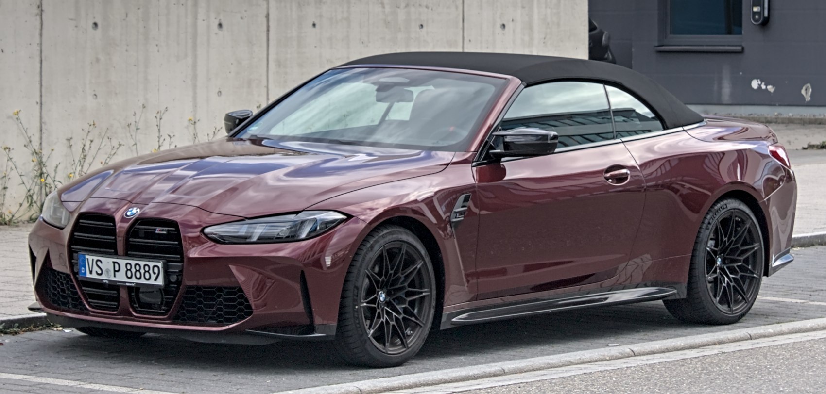 Front-side view of luxury sports convertible with soft-top and sporty black wheels
