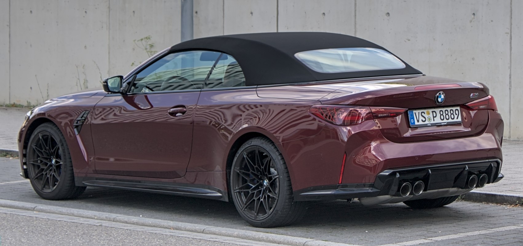 Soft convertible roof and quad exhaust on a sports coupe rear