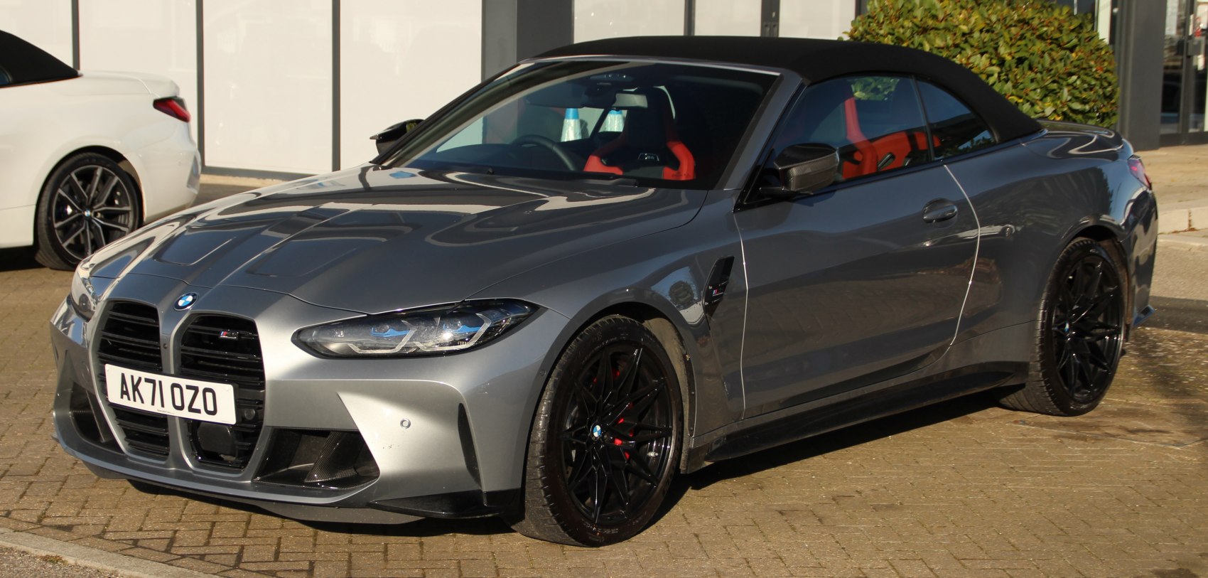 Grey soft-top convertible with aggressive front grille and black wheels